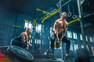 fit-young-man-lifting-barbells-working-out-in-a-gy-JUTEAYL.jpg